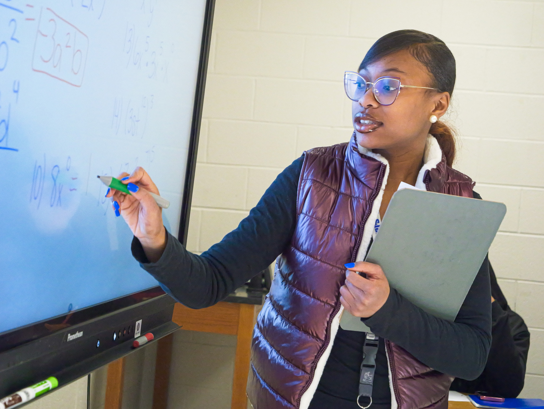 A Success Coach leading instruction at a whiteboard in a classroom