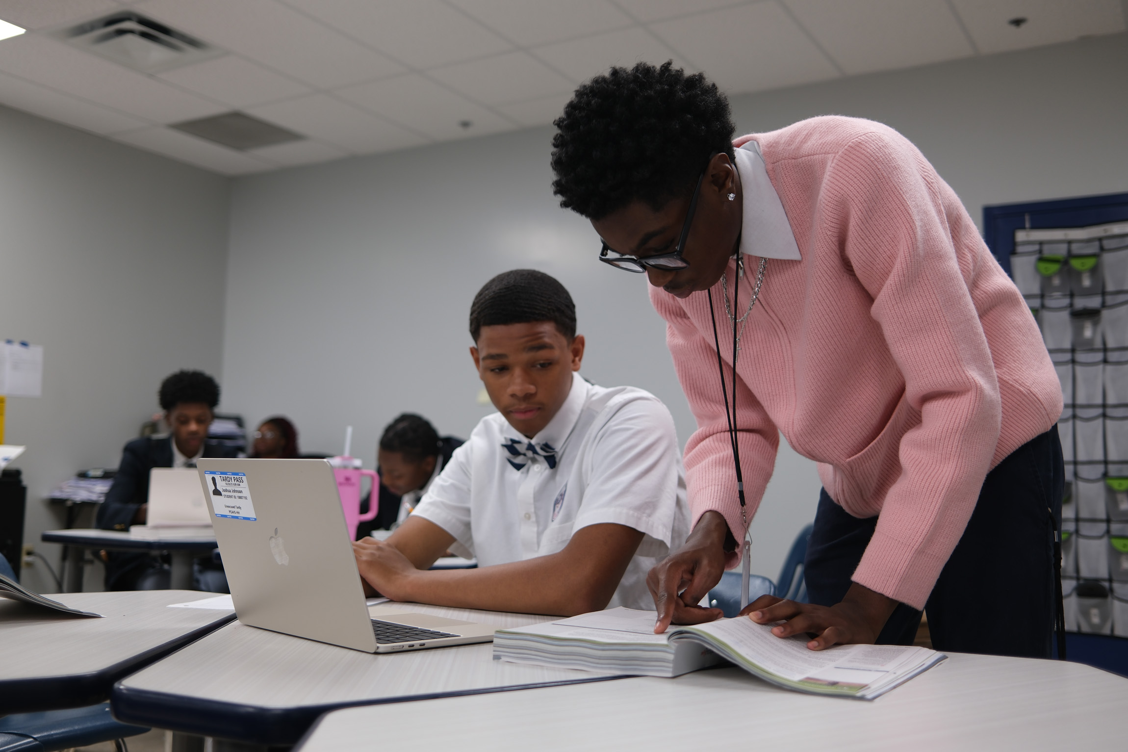 A Success Coach guides a student through material in a book during a tutoring session